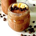 High protein chocolate pudding in mason jars topped with sliced banana and chocolate chips.