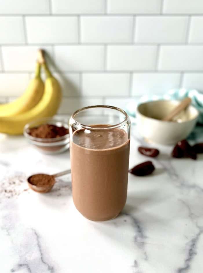 A chocolate tahini shake in a tall glass.