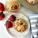 Healthy strawberry muffins in a muffin pan and on a plate strawberries.