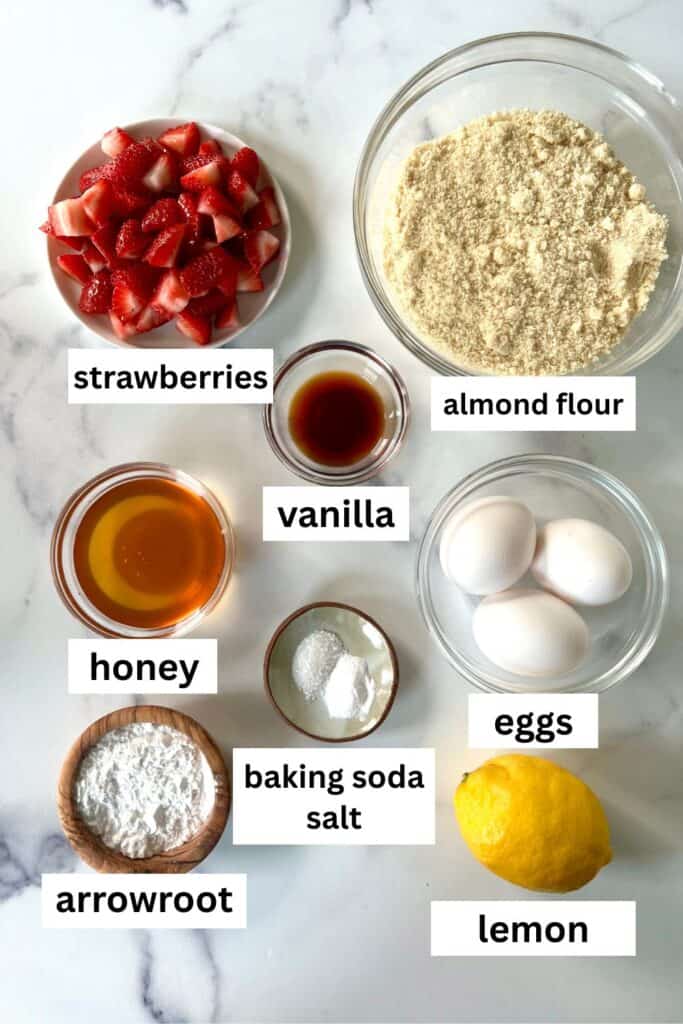 The individual ingredients for Gluten-Free Strawberry Muffins in bowls on a marble surface.