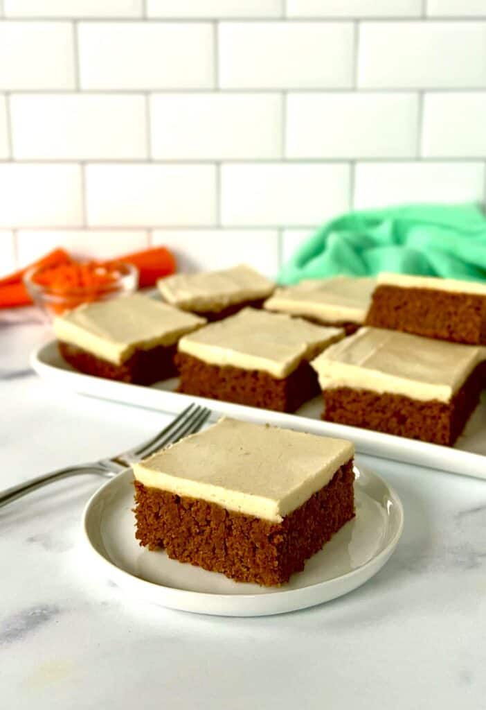 Gluten-free carrot cake bars on a small plate and on a rectangular platter.